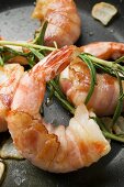 Bacon-wrapped king prawns in a frying pan (close-up)
