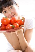 Young woman holding a bowl of tomatoes