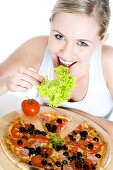 Young woman eating salad and pizza