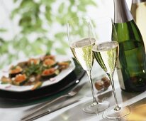 Glasses of sparkling wine, wine bottle, stuffed courgettes