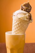 Caramel ice cream in wafer cone in orange beaker