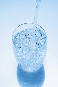 Wasser wird in ein Glas eingeschenkt