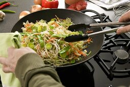 Vegetables in wok being stirred