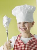 Girl in chef's hat and apron with beater