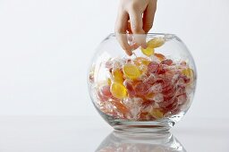 Child's hand reaching into a sweet jar