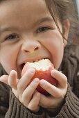 Mädchen beisst in einen Bio-Apfel