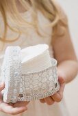 Girl holding crocheted container of cosmetic pads