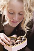 Young woman eating chocolates