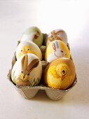 Easter eggs painted with animal motifs in egg box