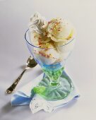 Vanilla ice cream with cream & sprinkles in a sundae glass