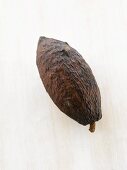 A cacao fruit on white wooden surface