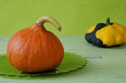A Hokkaido pumpkin and a black and yellow squash