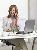 Businesswoman sitting at her desk making a phone call