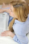 Blond woman reading a newspaper