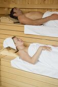 Man and woman lying in a sauna