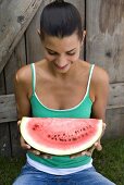 Young woman with slice of watermelon