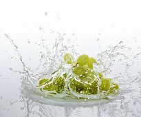 Grüne Trauben fallen ins Wasser