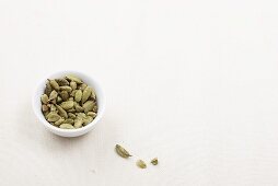 Cadamon capsules in a bowl and next to it