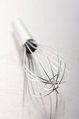 A whisk on a metal surface