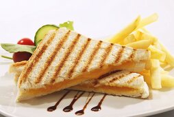 Toasted cheese sandwich with chips, balsamic vinegar and a salad garnish