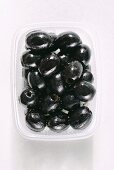 Stoned black olives in a plastic container