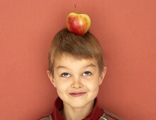 Kleiner Junge mit Apfel auf dem Kopf