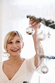 Young woman decorating Christmas tree