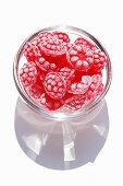 Raspberry sweets in a small glass bowl