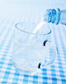 Mineralwasser in ein Glas gießen