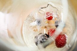 A glass of champagne with berry ice cubes