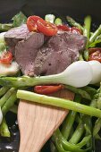 Roast beef with asparagus, tomatoes and spring onions