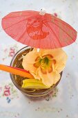 Cuba Libre with cocktail umbrella and amaryllis flower