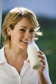 Junge Frau Trinkt Milch aus der Flasche