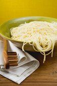 A dish of cooked spaghetti with spaghetti server