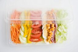 Bunter Salat mit Schinken und Ei in der Plastikschale