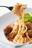 Spaghetti on fork with meatballs and tomato sauce