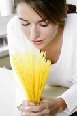 Woman looking at spaghetti in her hands