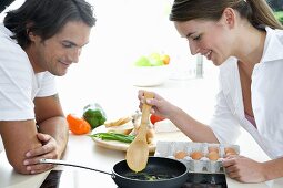 Young couple frying eggs in a frying pan