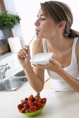 Young woman eating yoghurt