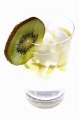 Mineral water with lime wedges, ice cubes and kiwi fruit