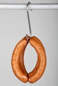 Four red bratwurst on a hook