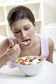 Frau isst einen Früchtejoghurt