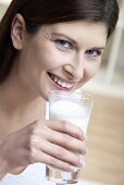 Frau hält ein Glas Milch in der Hand