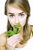 Young woman smelling fresh basil