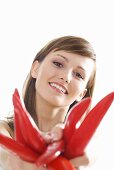 Young woman holding red chillies in outstretched hands