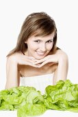 Young woman with lettuces in front of her