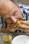 Man biting into a hot dog