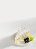 A piece of blue cheese with blackcurrants