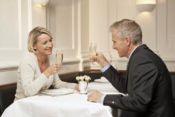 Smiling married couple raising glasses of sparkling wine