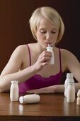 Young woman drinking out of plastic bottle through straw